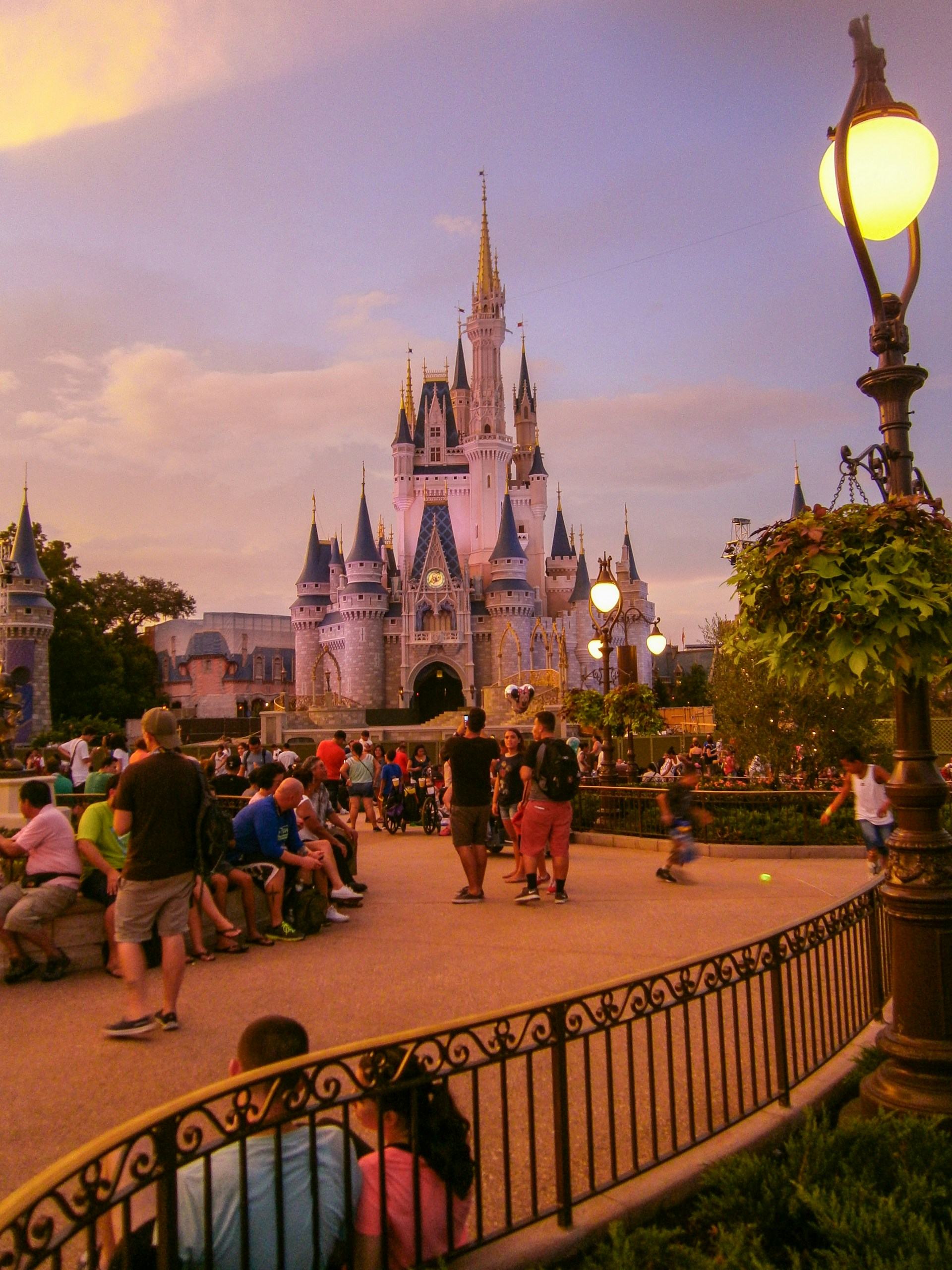 A vibrant group of teenagers enjoying the magical atmosphere in front of Cinderella's Castle at Disney.