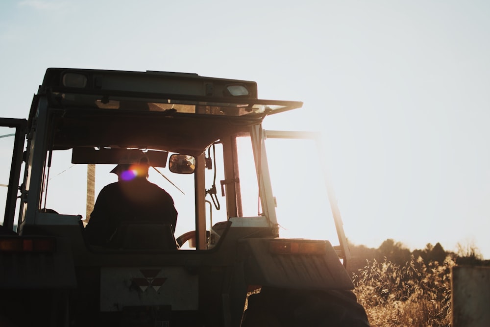 silhouette of man riding tractor