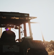 silhouette of man riding tractor