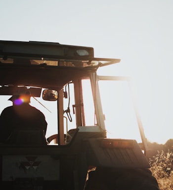 silhouette of man riding tractor