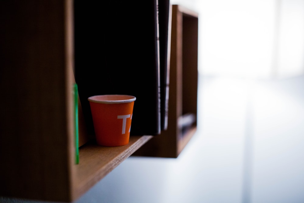 茶色の木製の棚に赤い使い捨てカップ