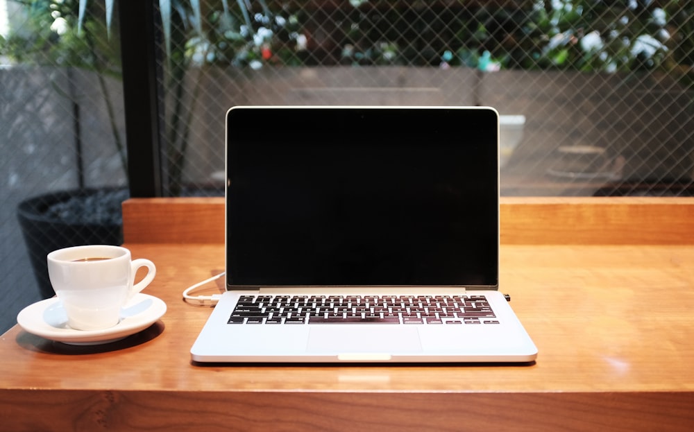 computer portatile accanto alla tazza di caffè