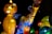 A collection of colorful, illuminated lanterns in the shapes of various animals and abstract figures, displayed against a dark background. The lanterns exhibit intricate patterns and vivid hues, creating a lively and festive atmosphere.