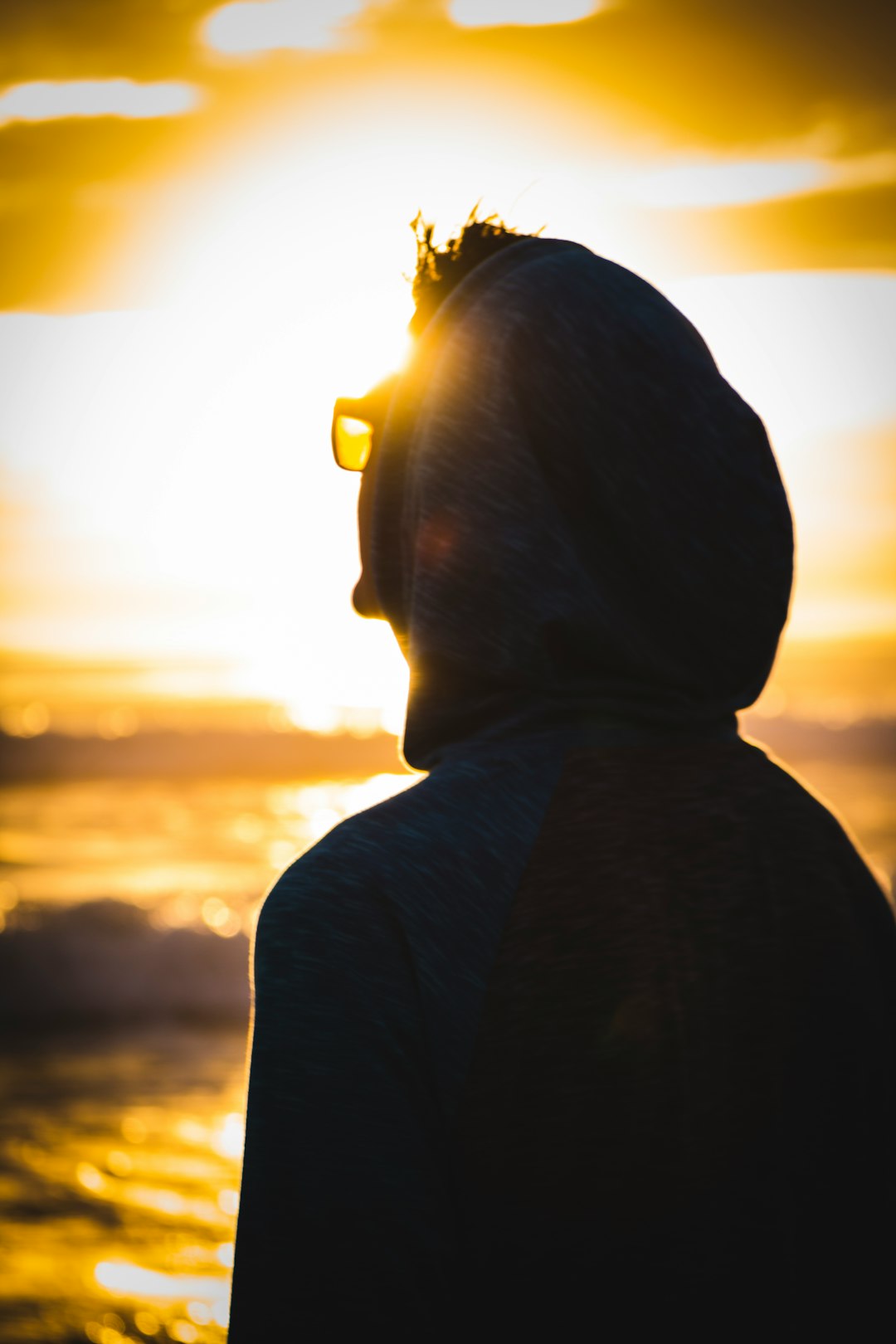 man wearing black hoodie during sunset