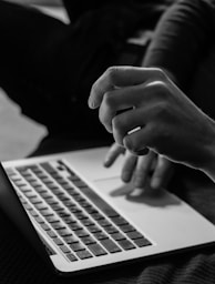 grayscale photo of person using MacBook