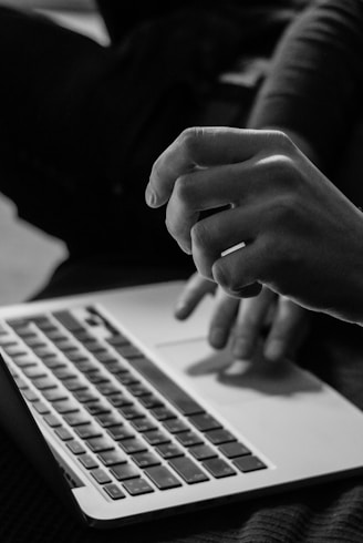 grayscale photo of person using MacBook