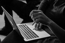 grayscale photo of person using MacBook