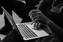 grayscale photo of person using MacBook