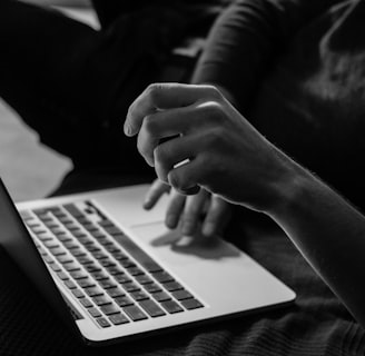 grayscale photo of person using MacBook