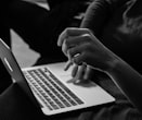 grayscale photo of person using MacBook