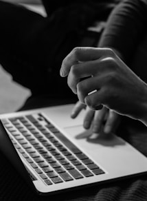 grayscale photo of person using MacBook