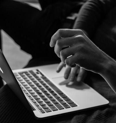 grayscale photo of person using MacBook