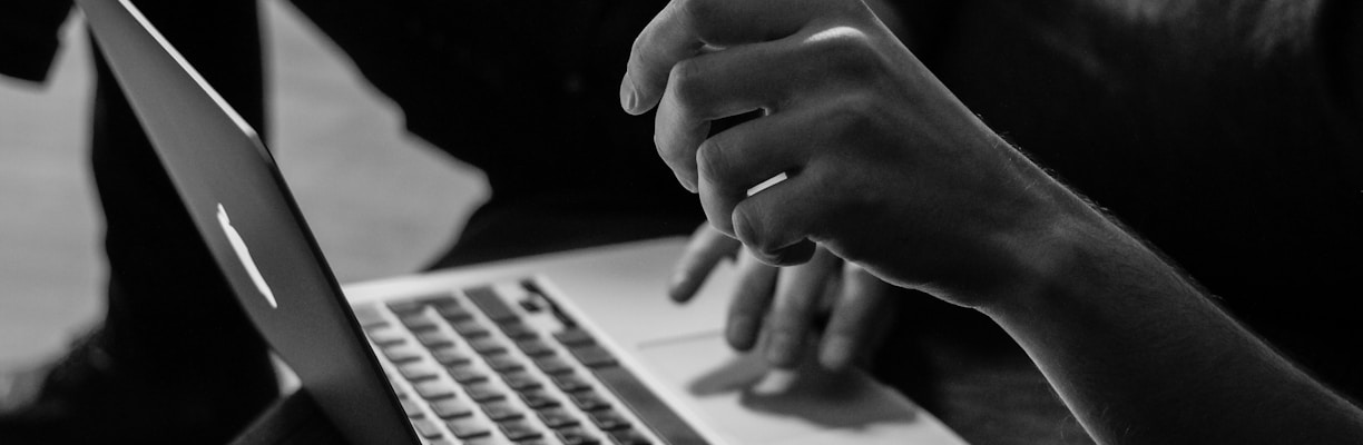 grayscale photo of person using MacBook