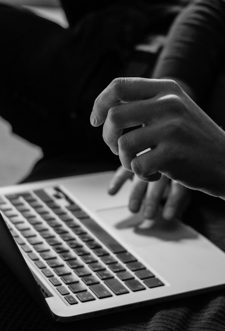 grayscale photo of person using MacBook