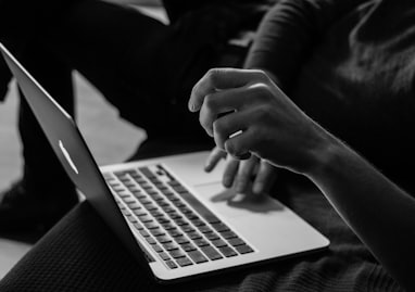 grayscale photo of person using MacBook