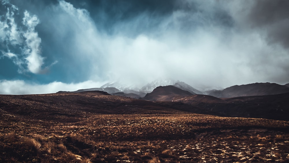 photo of mountains near on soil pavement