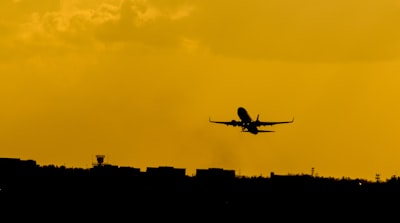 silhouette photo of flying airplane plane teams background