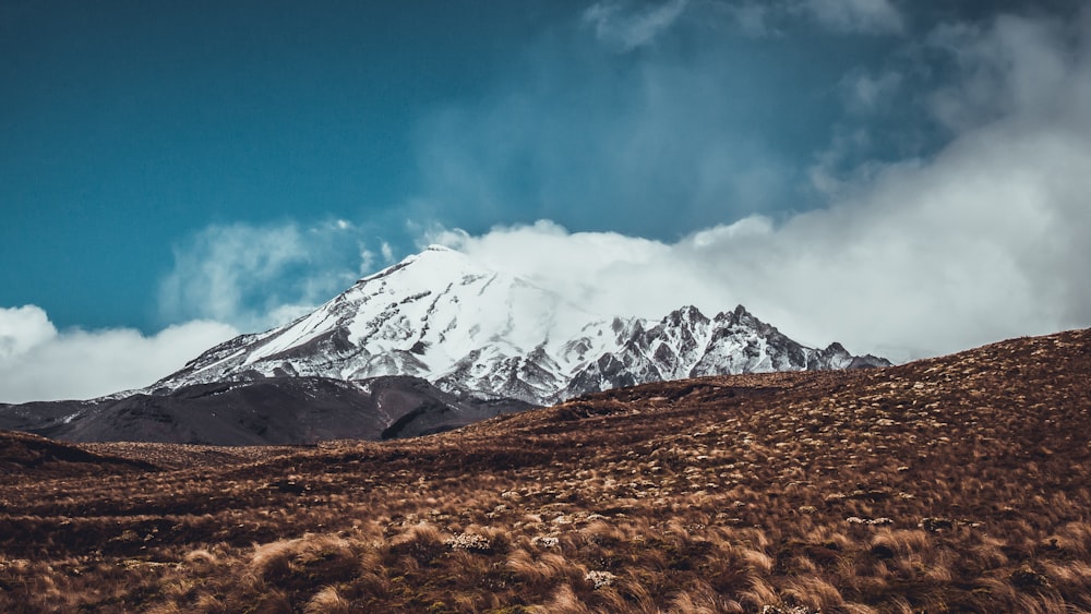 snow-covered mountain under white and blue sky