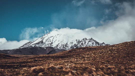 snow-covered mountain under white and blue sky in Tongariro National Park New Zealand