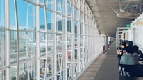 Project managers reviewing blueprints inside a modern airport terminal under construction.