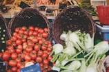 Baskets filled with ripe tomatoes and peppers at a local market stall.
