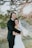 A joyful couple embracing during their outdoor wedding ceremony, surrounded by lush greenery and soft sunlight.