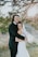 A joyful couple embracing during their outdoor wedding ceremony, surrounded by lush greenery and soft sunlight.