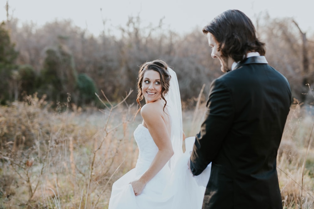 woman in white wedding dress and man in black suit jacket