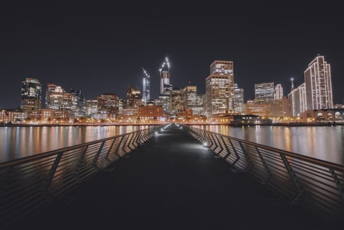 Pier 14 at night, looking towards downtown San Francisco's brightly lit buildings