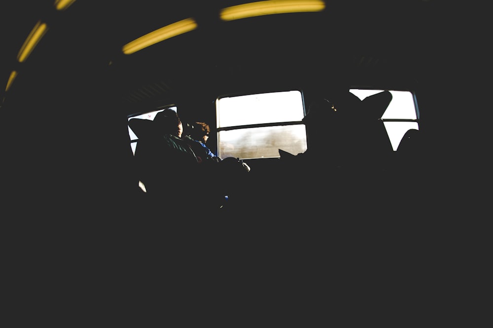 photo of four person sitting on chair in train