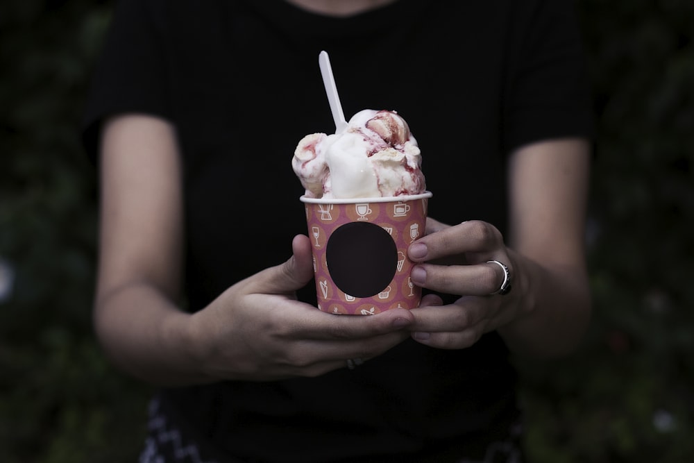 personne tenant un seau de crème glacée