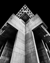 A stark black-and-white photo of Kinshasa's concrete architecture with bold geometric shadows.