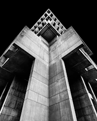 Monumental concrete architecture from Kinshasa bathed in stark black-and-white contrast.