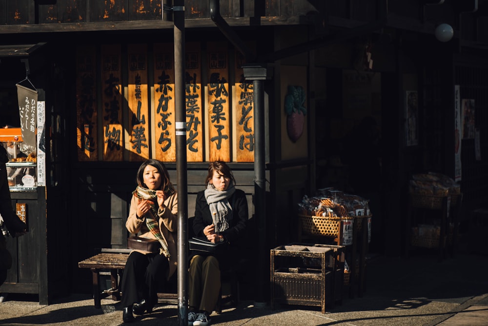 Dos mujeres sentadas en un banco al aire libre durante el día