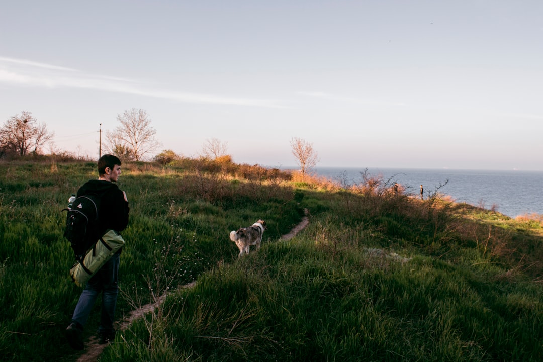 man walking on pathway nearby sea