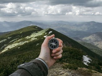 person holding silver compass