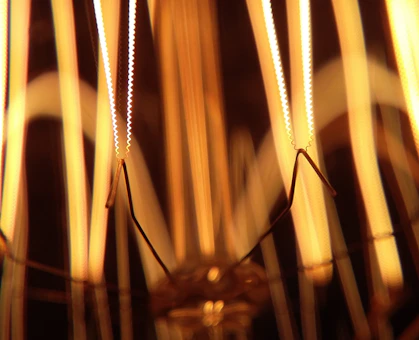 Close-up of a high-voltage transformer coil glowing under industrial lighting.