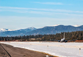 Beechcraft Baron taxiing on a runway with mountains in the background.
