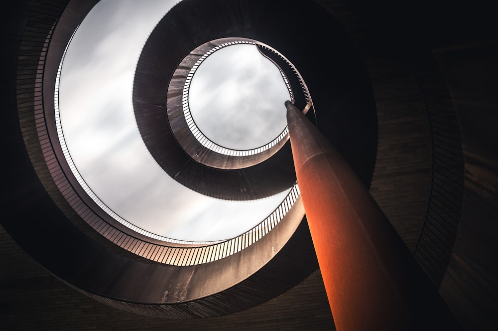 fotografia de baixo ângulo de escadas em espiral de concreto