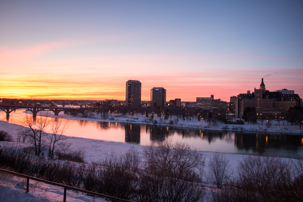 body of water beside cityscape during golden hour