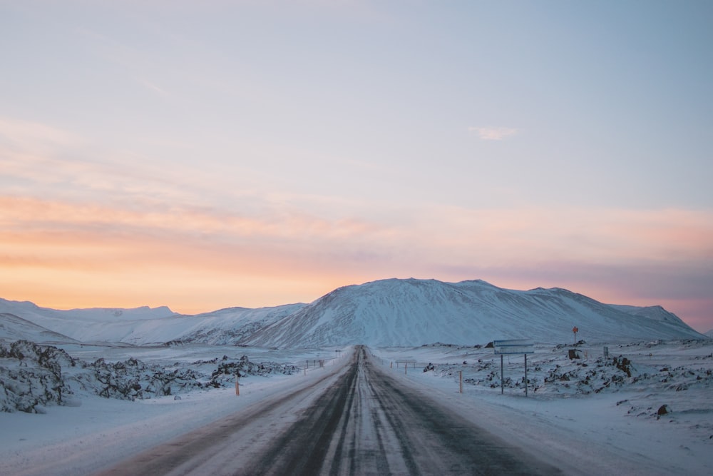 Fotografía de paisaje de carretera y montaña cubiertas de nieve