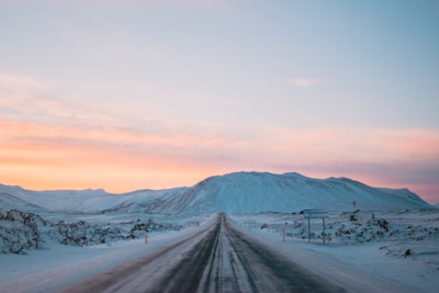 landscape photography of snow covered road and mountain icy teams background