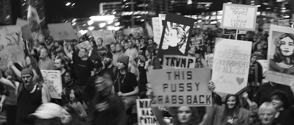 grayscale photo of people holding signages