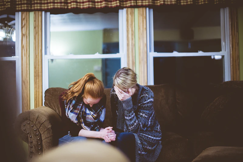Two people talking together on a couch