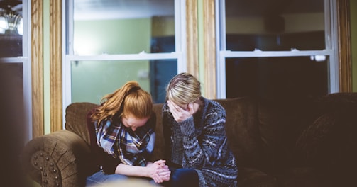 man and woman sitting on sofa in a room