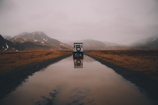 white and black vehicle on road with water during daytime in Skógar Iceland