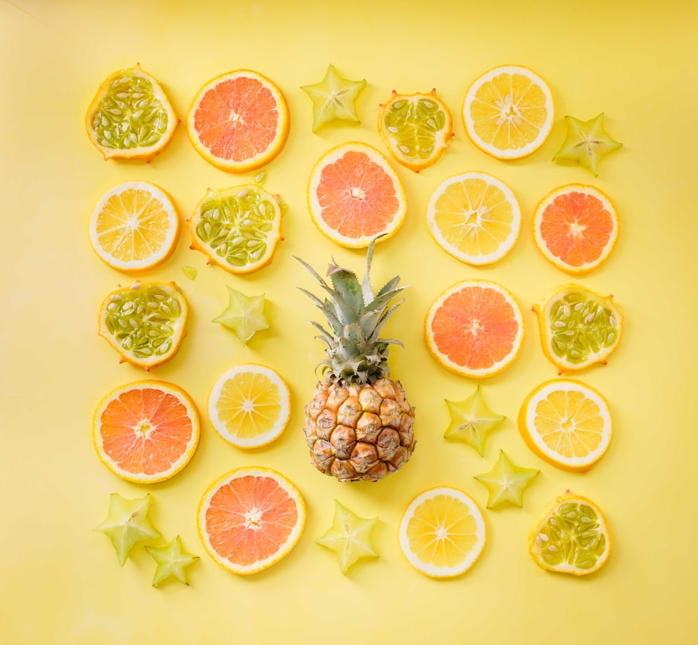 pineapple surrounded by citrus fruits