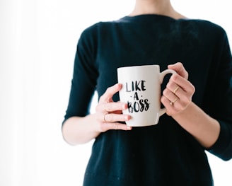 woman holding white mug while standing