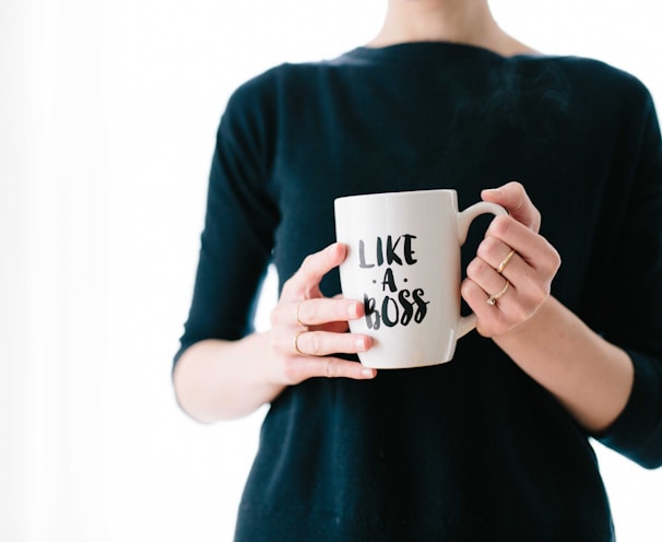 woman holding white mug while standing