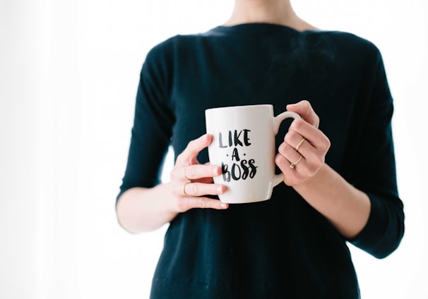 woman holding white mug while standing